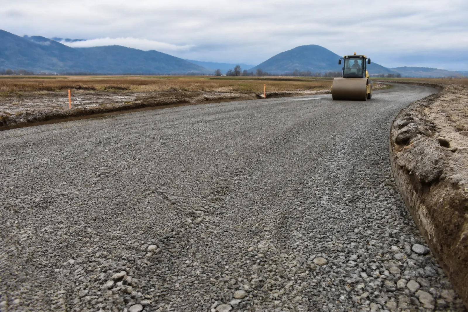 Compacted crushed aggregate base being prepared before asphalt placement